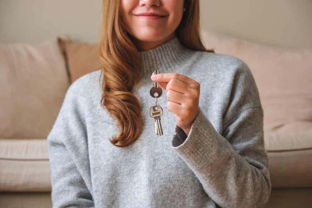 Woman holding keys signifying real estate concept representing California landlords making passive income through 1031 exchanges