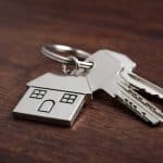 Close up of house keys on a house shaped keychain symbolizing key considerations for replacement property rules in a 1031 exchange highlighting the tax benefits and real estate investment opportunities